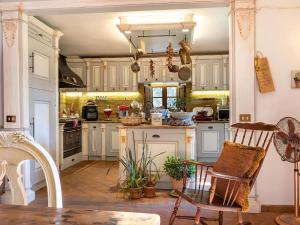a kitchen with white cabinets and a table and chairs at Villa With Pool, Gym, Pond And Panoramic Views in Laterina