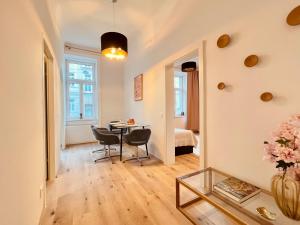ein Wohnzimmer mit Tisch und Stühlen in der Unterkunft SERVUS HOMES Schönbrunn I Top-Lage & Metro in Wien