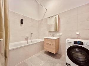 ein Badezimmer mit Waschmaschine und Waschbecken in der Unterkunft SERVUS HOMES Schönbrunn I Top-Lage & Metro in Wien