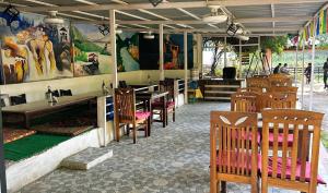 ein Restaurant mit Holzstühlen und Tischen in einem Raum in der Unterkunft Rishikesh Valley in Rishikesh