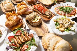 a table full of different types of food on plates at Magic Moment Resort & Kids Club, Dazzler Select by Wyndham in Kissimmee