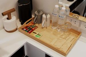 a wooden cutting board with water bottles on a counter at Continuum Hotel Udonthani in Udon Thani