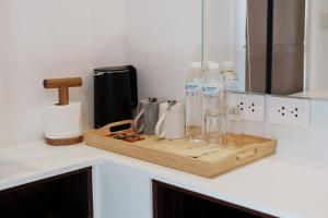 a kitchen counter with a cutting board and water bottles at Continuum Hotel Udonthani in Udon Thani +49 photos