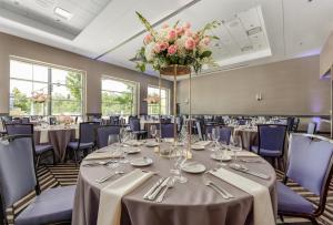 a banquet room with tables and chairs and a vase of flowers at Hyatt Centric Chicago Ohare in Rosemont
