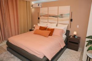 a bedroom with a large bed with orange pillows at Serene Mountain View Smart Apt for Restful Stays in Castries