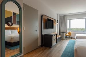 a hotel room with a bed and a mirror at Hyatt Centric Chicago Ohare in Rosemont +90 photos