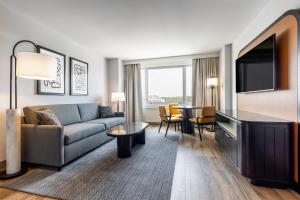 a living room with a couch and a flat screen tv at Hyatt Centric Chicago Ohare in Rosemont