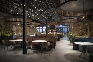 a restaurant with tables and chairs and lights at Hyatt Place Guyana Georgetown in Georgetown