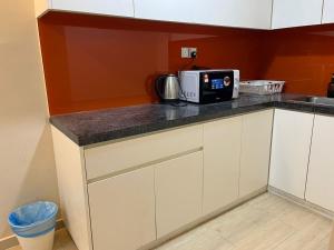a kitchen with a counter top with a microwave at Centrestage PJ by Master House in Petaling Jaya +36 photos