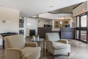 a lobby with chairs and a table and a kitchen at Comfort Inn in Huntsville