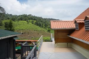 a balcony of a house with a view of a mountain at The Door to Nirvana Backpackers Hostel Kotagiri in Kotagiri +49 photos