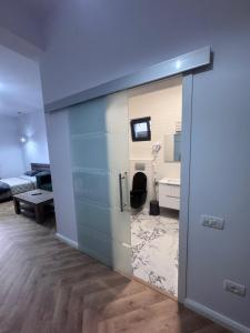 a room with a sliding glass door with a bathroom at Pensiunea EUPHORIA in Sviniţa +68 photos