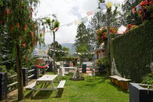 a park with a picnic table and a fence with flowers at The Door to Nirvana Backpackers Hostel Kotagiri in Kotagiri