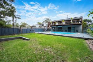 an empty yard with a playground and a building at Drifters @ Callala Beach in Callala Beach