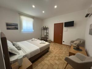 a bedroom with a bed and a chair and a television at Agriturismo Valle di Chiaramonte in Chiaramonte Gulfi