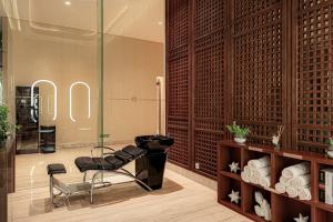 a room with two chairs and a glass wall at Vasa Suite Surabaya in Surabaya
