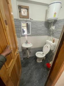 a bathroom with a toilet and a sink at Sajjus Riverside Retreat in Manāli
