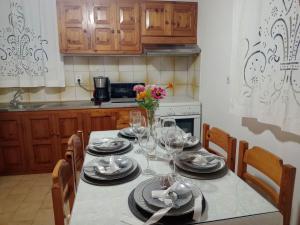 a kitchen with a table with plates and wine glasses at Villa Makris in Zenempisátika