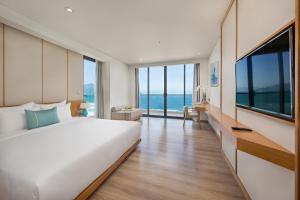a hotel room with a bed and a large window at TMS Hotel Da Nang Beach in Danang