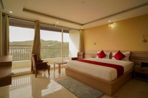 a hotel room with a bed and a large window at Shree Goljyu Palace in Almora