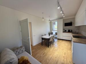 a kitchen and a living room with a table in a room at Apartamentul white Arena in Chişinău