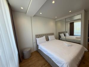 a bedroom with two beds and a large mirror at Apartamentul white Arena in Chişinău