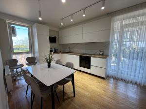 a kitchen with a table and chairs in a room at Apartamentul white Arena in Chişinău