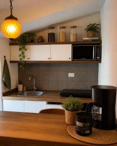 a kitchen with a sink and a microwave at Apartamento de confort en el Centro Histórico de Cusco in Cusco