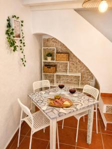 a dining room with a table with two glasses of wine at La Casita Vertical casco histórico de Segorbe in Segorbe