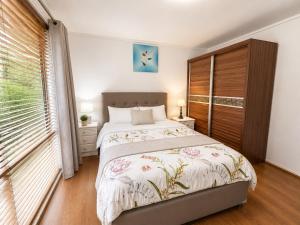a bedroom with a bed and a large window at Apollo bay Holiday House in Apollo Bay