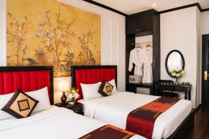 a hotel room with two beds and a painting on the wall at Hanoi Sena Hotel & Travel in Hanoi