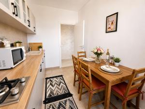 a kitchen and dining room with a wooden table and chairs at CENTRAL Apartment 84- free parking- spital Recuperare in Iaşi