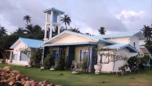 a house with a clock tower on top of it at Refuge Boutique Villa in Hikkaduwa