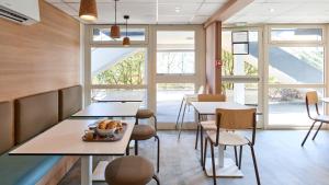 a restaurant with tables and chairs and windows at Premiere Classe Boissy St Leger in Boissy-Saint-Léger