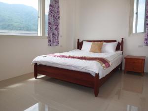 un letto in una stanza bianca con una finestra di Village Tree B&B a Ji'an