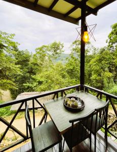 a table and chairs on a balcony with a view at The Mist in Ella