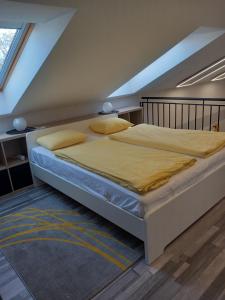 a bedroom with a large bed in a attic at Gemini Apartman in Esztergom