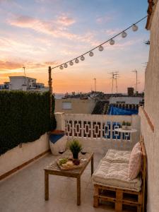 a patio with a table and a couch on a balcony at La Casita Vertical casco histórico de Segorbe in Segorbe