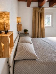 two beds in a bedroom with two lamps and a window at La Casita Vertical casco histórico de Segorbe in Segorbe