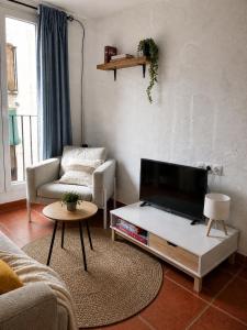 a living room with a flat screen tv on a table at La Casita Vertical casco histórico de Segorbe in Segorbe
