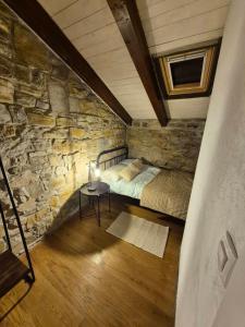 a room with a bed and a stone wall at Vila EVANA in Sečovlje