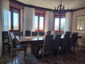 a dining room with a large wooden table and chairs at Villa Martini dei Rossi in Sanfrè