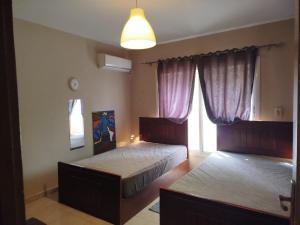 a bedroom with two twin beds and a lamp at Madinaty Summer cottage in Cairo