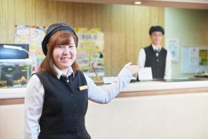 une femme devant un registre de caisse dans l'établissement Select inn Iwaki Ekimae, à Iwaki