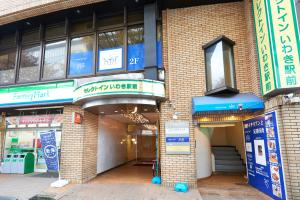 una tienda frente a un edificio con letreros. en Select inn Iwaki Ekimae, en Iwaki