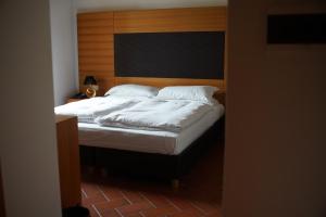 a bedroom with a bed with a wooden headboard at Relais Palazzo Lodron in Rovereto +51 photos