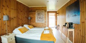 a bedroom with a bed in a wooden wall at Vega Havhotell in Vika