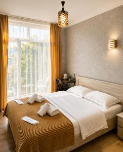 a bedroom with a large bed with towels on it at Hotel Marioni in Tbilisi City +31 photos