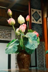 a vase filled with pink and white flowers on a table at NorthWest Home in Mai Châu