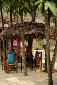 two people sitting at a table under a thatch hut at NorthWest Home in Mai Châu